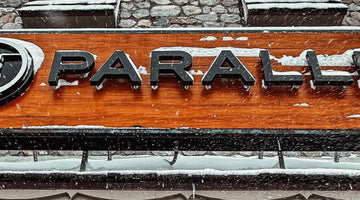 Snow falling outside the 45th Parallel store in Gaylord, Michigan, with a snowboarder wearing a 45th Parallel hoodie
