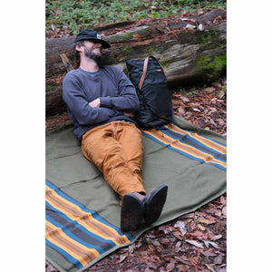 45th Parallel Canvas Waterproof Outdoor Blanket at campsite with log