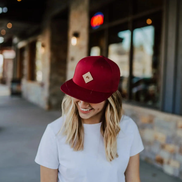 Woman wearing 45th Parallel Three Tree Leather Patch Flat Brimmed Hat in burgundy