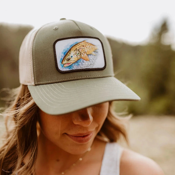 Woman wearing 45th Parallel Trout Patch Trucker hat in nature