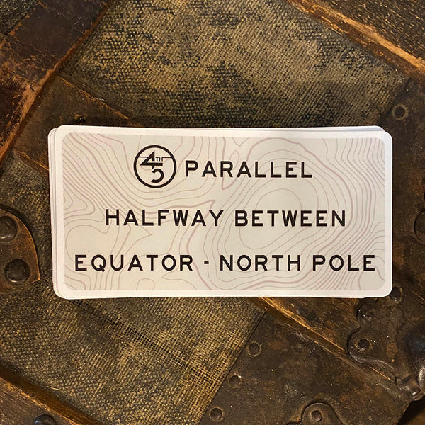 Tan 45th Life Halfway sticker with topographic pattern and “Halfway Between Equator - North Pole” text on durable vinyl.